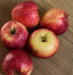 Fresh red and yellow royal gala apples on wooden background