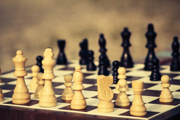 Close up white and black wooden chess pieces on board