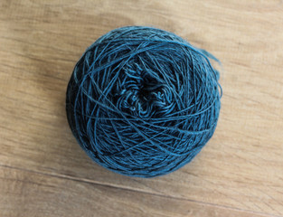 Dark blue homemade spun ball of wool on wooden background