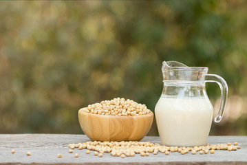 Soy milk and soy beans on wood background.