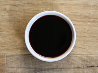 white bowl with sweet soy sauce on wooden background