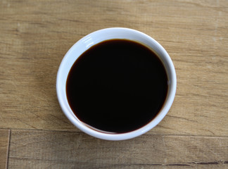 white bowl with sweet soy sauce on wooden background