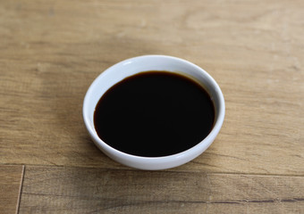 white bowl with sweet soy sauce on wooden background