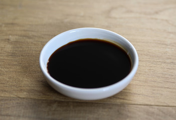 white bowl with sweet soy sauce on wooden background