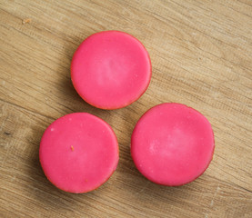 mini pink fondant cakes on wooden background