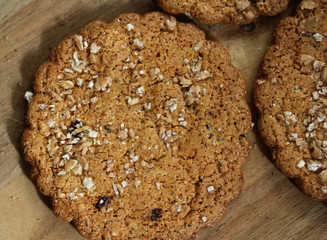 Round brown granola whole wheat oat cookies with raisin on wooden background
