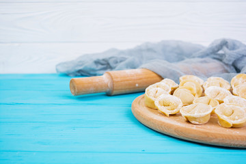 Homemade raw dumplings, pelmeni, on wooden background.