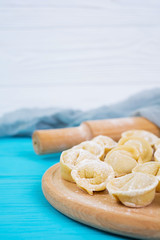 Fototapeta na wymiar Homemade raw dumplings, pelmeni, on wooden background.
