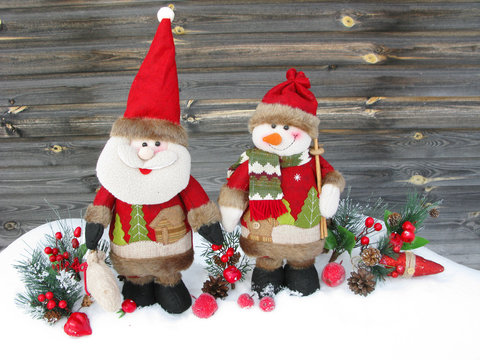 christmas santa snowman decoration winter berries and snow on wooden background