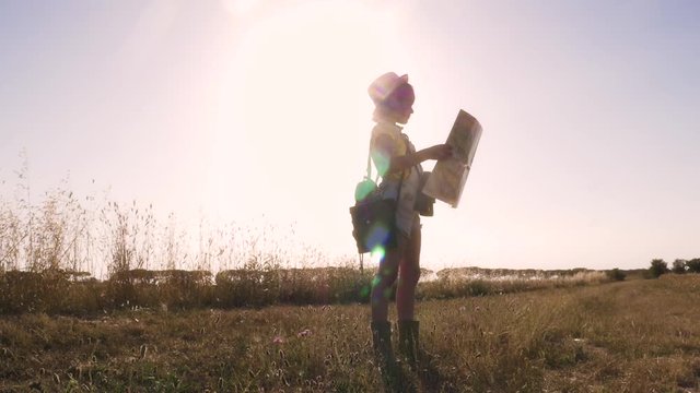 Little Girl Holding a Map in open field looking around for directions lost in golden wheat field slow motion