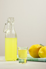 limoncello on a light background. summer traditional Italian drink of home-made liqueur from Sicilian lemons. Alcoholic drink is yellow. articles made of fruits.