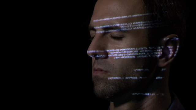 Close up of ai software developer man with beard keeping his eyes closed and moving his head while programming code is reflected on his face