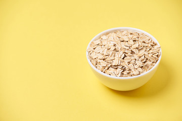 Muesli for breakfast. Healthy food. Yellow background. White bowl