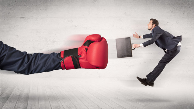 Arm with boxing gloves hits office worker concept