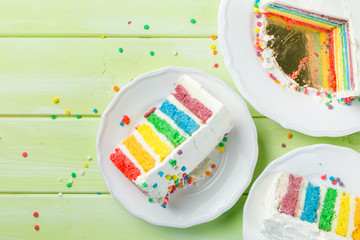 Naklejka premium Birthday background - striped rainbow cake with white frosting
