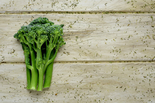 stems of broccolini on a wooden surface