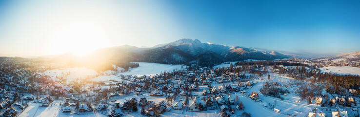 aerial view of a small snowy town and mountains in winter