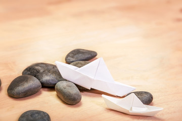 Paper Boats and Rocks on Wood Background, Leadership an Go Over Obstacle Concept