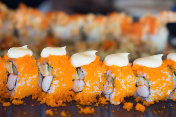 Sushi roll with shrimp eggs and cream cheese on top