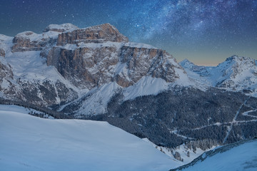 Fantastic starry sky. Panoramic view of the Val Di Fassa ski resort of the Italian Dolomites under...