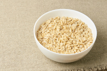 Light background. White bowl. Healthy food. Oatmeal porridge