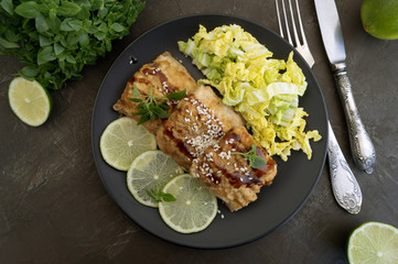 Fried fish with salad on a gray plate.