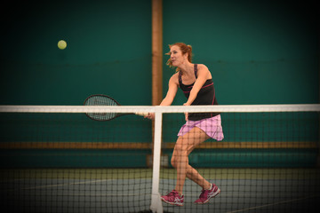femme jouant au tennis dans un gymnase