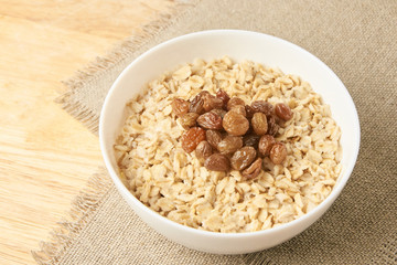 Oatmeal with raisins. Delicious healthy breakfast. Neutral background