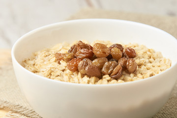 Oatmeal with raisins. Delicious healthy breakfast. Neutral background
