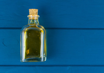 Bottle with elixir on a blue wooden background.