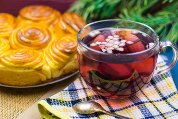 A cup of fruit tea on the background of homemade cakes.