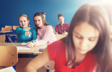 students gossiping behind classmate back at school