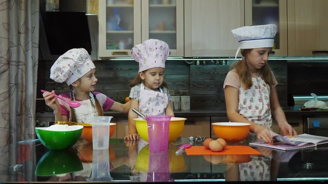 Children mixing flour with already beaten up eggs and sugar using an hand mixer