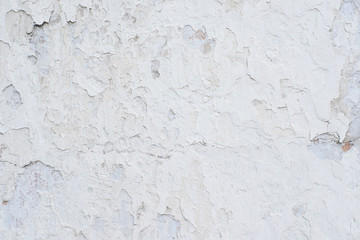 White peeling paint. Many small cracks. Uneven surface