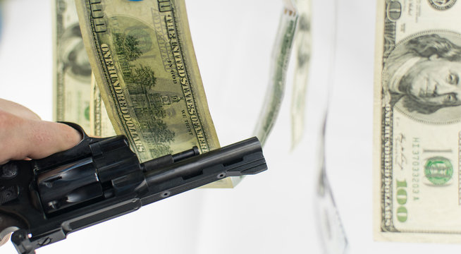 Pistol and money on a white background. The concept of crime is because of money.