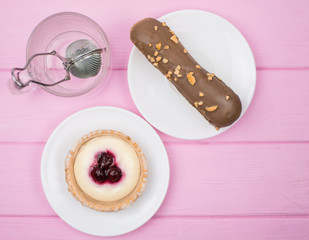 Cake and tea in a glass on a pink wooden background.