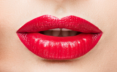 Obraz premium The female lips which are made up by red lipstick.