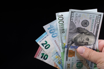 Hand holding American dollar  isolated on black background