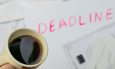 Procrastination concept: Drink coffee, when you can already see deadline. A cup of coffee on the...