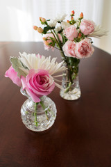 Two crystal vases with roses and miniature flowers