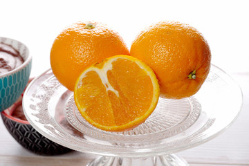 close up of oranges in a glass dish