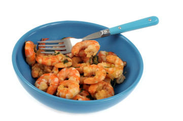 Crevettes décortiquées dans une assiette avec une fourchette sur fond blanc