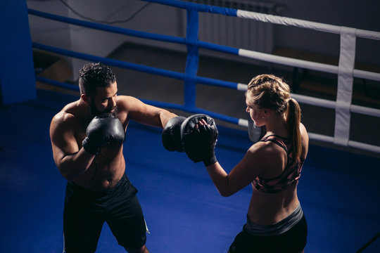muscular young man and woman boxing together