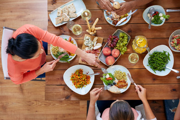 group of people eating at table with food