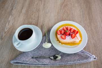 Cake and strawberries on wood background.