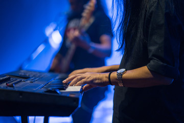 Pianist playing electric piano in concert, music concept.