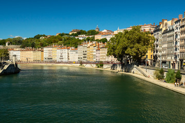 Saône river quay during the summer day with Saint-Vincent bridge and old buildings on a background. Lyon, France.