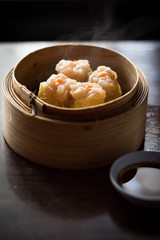 Shrimp Shumai, a steamed dish in bamboo containers with soy sauce