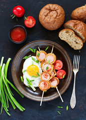 Fried egg with sausages wrapped in pancakes for breakfast.