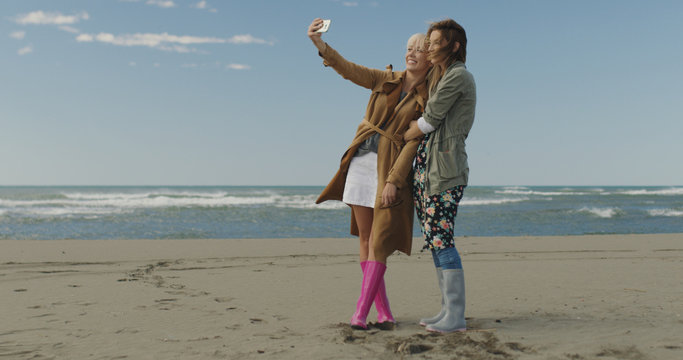 Girls having time and taking selfie on a beach